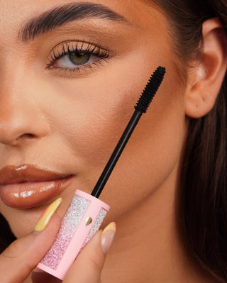P.Louise Cry Baby 睫毛膏棒与粉红色闪光睫毛膏管靠近人眼的特写。