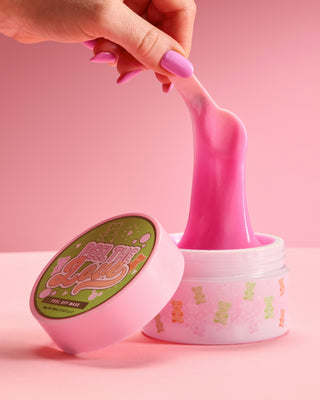 P. Louise Peel The Love Peel Off 面膜的浴缸被用粉红色背景的涂抹器从浴缸中拉出