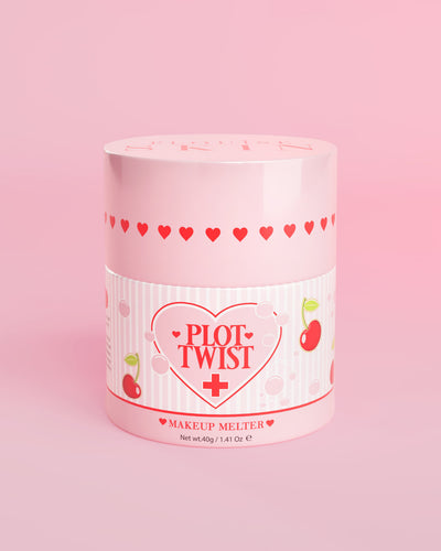粉红色容器,装有 P.Louise Plot Twist Makeup Melting Cleansing Balm,标签上有心形和樱桃图案,背景为粉红色