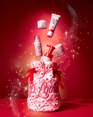 粉色圣诞 P.Louise 包，上面有红色节日蝴蝶结和节日设计，红色背景上顶部有身体护理产品