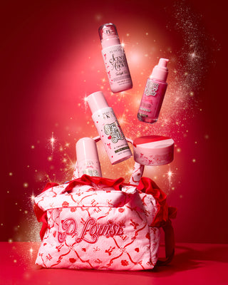 Pink P.Louise Christmas skincare gift set bag with festive design in twilight tide scent with products coming out the back against a red background