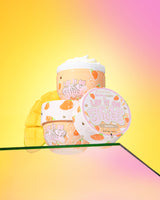 Three containers of P. Louise 'Lift It On Thick' mango body butter on a gradient yellow and pink background